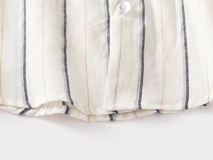 Detailed close-up of a striped cotton linen shirt hem and a white translucent button