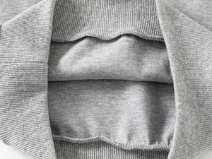Detailed macro view of gray knitted fabric texture with ribbed cuffs and stitching