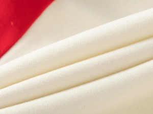 Détail du tissu en maille de coton crème doux avec épissage rouge pour cet ensemble enfant