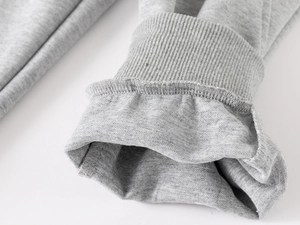 Gros plan détaillé du pantalon en maille gris clair avec finitions bords-côtes et coutures