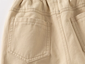 Detail of khaki cotton trousers showing reinforced back pocket stitching and elastic waist