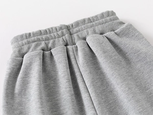 Détail de la taille élastiquée côtelée haute élasticité sur pantalon de jogging gris clair