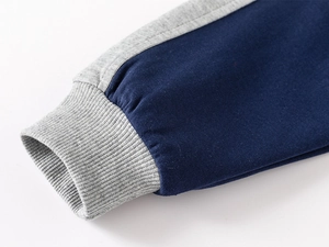 Detailed shot of navy blue kids' tracksuit ribbed cuffs with gray contrast stitching