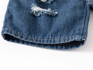 Détail du short en jean pour garçon avec effets déchirés et ourlet à double surpiqûre