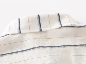 Detailed macro view of the lapel collar and cotton-linen texture on striped shirt