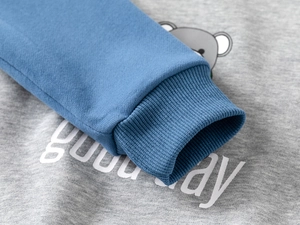 Detail of baby boys cotton sweatshirt with ribbed blue cuff and cute cartoon bear print