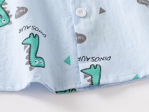 Detailed macro shot of blue cotton fabric with dinosaur print and white resin button
