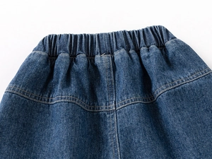 Détail de short en jean pour garçon avec taille élastique et surpiqûres jaunes