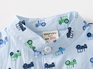 Detail of baby boy light blue shirt with tractor print and white button closure