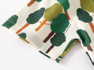 Detail of boys summer shirt sleeve showing digital tree print and cotton fabric texture