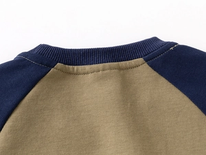 Macro detail of navy rib knit neckline and raglan sleeves on green cotton sweatshirt