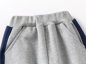 Detail of children's grey jogger waistband with navy side stripes and elastic ribbing