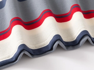 Gros plan du tricot en coton rayé et des coutures précises sur l'ourlet du polo pour garçon