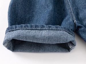 Vue détaillée du short en jean montrant l'ourlet replié et les surpiqûres contrastées