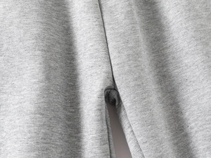 Close-up of light grey knit joggers showing smooth stitching and breathable fabric texture