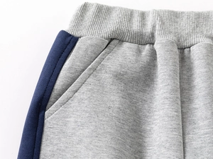 Close-up of grey and navy kids' joggers showing ribbed waist and knit texture details