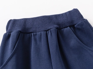 Detail of ribbed elastic waistband and side pockets on navy knit cotton joggers