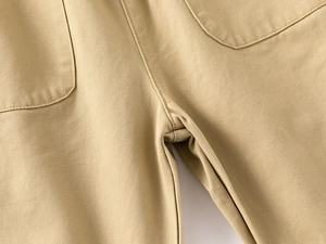 Détail du pantalon en coton kaki montrant les coutures renforcées et la poche arrière