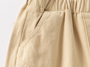 Détail d'un pantalon kaki pour garçon avec taille élastique et poches latérales