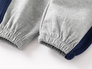 Close-up of elastic ribbed cuffs on a navy blue and grey knit kids sports tracksuit