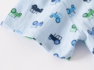 Detail of baby boy short sleeve shirt cuff with tractor print and neat stitching