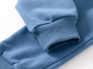 Detail view of the ribbed knit cuff on this blue long-sleeve cotton fleece sweatshirt