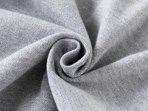 Close-up of grey knitted cotton fabric showing soft texture and detailed weave pattern