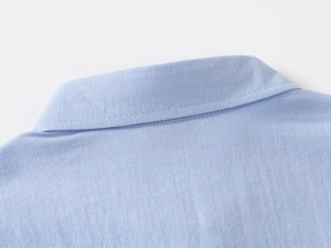 Close-up of boys light blue twill shirt collar featuring precise stitching details