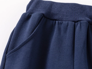 Close-up of navy blue children's sweatshirt pants with elastic ribbed waistband and pockets