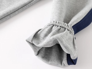 Macro view of light grey cotton knit cuffs with navy side stripes and elastic frill detail