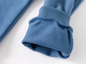 Close-up of ribbed cuffs and soft French Terry lining on blue cotton hoodie