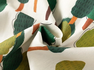 Macro shot of cotton linen shirt fabric with illustrated forest pattern and texture
