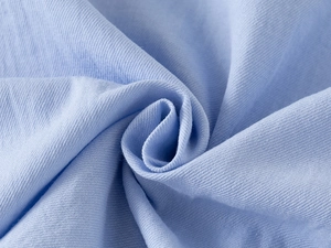 Close-up of light blue cotton fabric texture with intricate woven breathable patterns