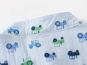 Close-up of boys light blue cotton shirt collar with colorful tractor print