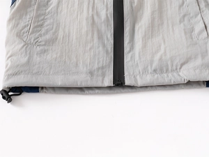 Close-up of lightweight jacket hem with waterproof zipper and adjustable drawstring buckle