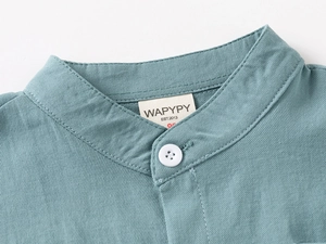 Close-up of V-neck collar on cyan blue kids shirt with white buttons and twill texture