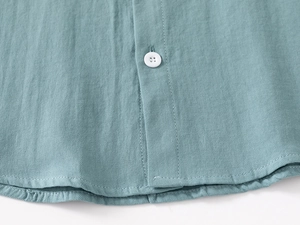 Detail view of cotton blend kids shirt showing twill fabric texture and white button