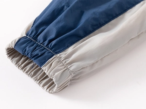 Detailed close-up of navy and light grey color-block elastic cuffs with fine stitching
