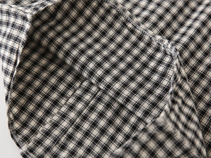 Close-up of black and white gingham shirt hem with precision stitching and fine seam detail