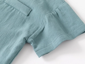 Detail of teal cotton-linen boy shirt showing breathable fabric texture and neat chest pocket