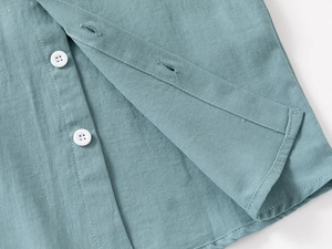 Close-up of gray-blue kids shirt showing twill fabric texture and white button detail