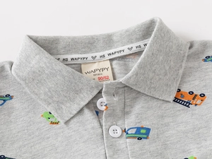 Detail of kids polo shirt with colorful cartoon construction truck prints and buttons