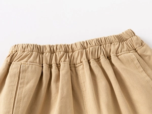 Detailed close-up of khaki cotton shorts featuring an elastic waistband and neat stitching