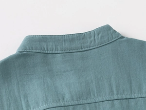 Detailed macro view of teal V-neck shirt neckline with reinforced stitching and twill fabric