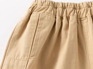 Detail of khaki cotton shorts showing the elastic waistband and reinforced side pockets