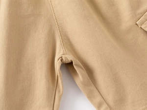Close-up of double-stitched seams and twill cotton fabric on khaki boy's shorts