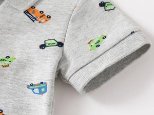 Detailed close-up of gray piqué cotton fabric and colorful cartoon vehicle prints on polo shirt