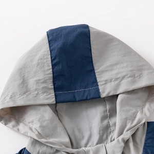 Kids thin hooded windbreaker with grey and blue color block design and zip closure