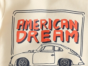 Detailed close-up of American Dream red lettering on a beige cotton knit sweatshirt
