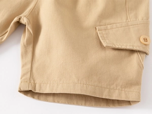 Close-up of khaki cotton cargo shorts detail showing side pocket and durable stitching